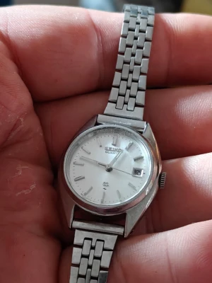 Seiko's Silver - Klassisk Seiko armbandsklocka i rostfritt stål med silverfärgad länk och vit urtavla.. Klockan har datumvisning och tydliga markeringar. Perfekt för dig som gillar stilrena accessoarer och tidlös design. Silver har testats och fungerar men batteriet som sitter i är för litet 
