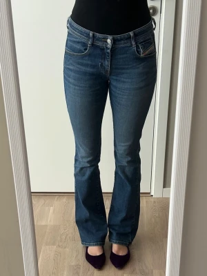 Diesel bootcut jeans - Mörkblå Diesel bootcut jeans som tyvärr inte kommer till användning längre. Klassisk femficksmodell och normalhög midja. Jeansen har en lätt utsvängd passform nedtill och är tillverkade i ett mjukt denimtyg. Perfekta till sneakers eller klackar för en trendig look. Lätt slitna nertill på baksidan av jeansen (andra bilden)💕