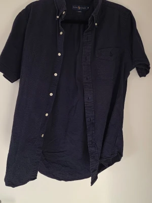 Mörkblå kortärmad Ralph Raulen skjorta - Jätte snygg mörkblå skjorta. Enkel att matcha med olika outfits. 