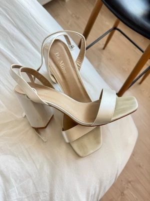 Be mine klackskor  - Be mine klackskor i satin liknande material. Vit/ivory färg. Använd 1 kväll på min studentbal. Originalkartong medföljer🤍Strl 40 men passar även 39