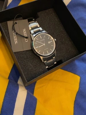     🌟 Ny Citizen-klocka | Aldrig använd | Kvitto finns - ⌚️ Citizen-klocka säljes ✨ Helt ny och aldrig använd. Klockan är i nyskick utan några repor eller tecken på användning. Originalkvitto finns och medföljer vid köp. 🧾  Säljer den då den inte kommer till användning. En stilren och kvalitativ klocka som passar både till vardags och finare tillfällen.  💬 Priset är absolut inte fast, jag är öppen för bud och smidiga affärer. Skicka gärna ett meddelande om du har frågor eller vill lägga ett bud! 😊