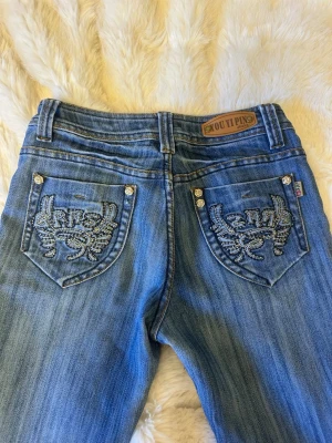 Jeans med broderidetaljer - Knappt använda. Mått finns på bilderna! 