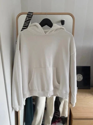 Vit hoodie - Snygg vit hoodie i oversized modell med stor känguruficka framtill och luva. Tillverkad i mjukt bomullsmaterial som känns skönt mot huden. Perfekt för en avslappnad och trendig look. Rökfritt hem men hundar och katt finns i hemmet 