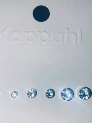 Kappahl örhängen med strass, 6-pack - Snyggt 6-pack örhängen från Kappahl med glittrande, runda strass-stenar i olika storlekar. Perfekta att mixa och matcha för en personlig stil. Färgen är klar och materialet är metall med strass.
