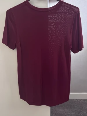 Mörkröd basic t-shirt - En enkel och stilren mörkröd t-shirt med rund hals och korta ärmar. Perfekt att matcha med jeans eller shorts för en clean look. Tillverkad i mjukt material som känns skönt mot huden.