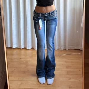Lågmidjade bootcut jeans - Vintage från Success med lapp kvar💓midja 39, innerben 84. Tjejen på bilden är 165. Jeansen är i använt skick men inga märkbara defekter. Köptes för 700 på Plick.