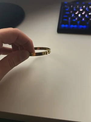 Guldigt stelt armband - Snyggt stelt armband i guldfärgad metall med enkel och stilren design. Armbandet har ett smidigt lås och passar perfekt för dig som gillar minimalistiska accessoarer. Perfekt att matcha med andra smycken för en personlig stil.