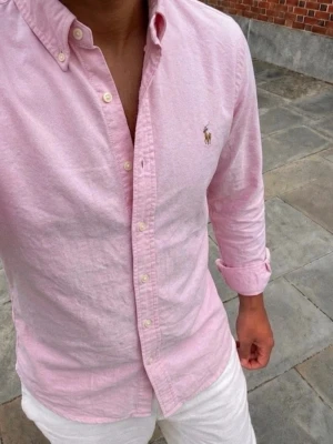 Ralph Lauren Skjorta  - En otroligt snygg rosa ralph lauren skjorta, perfekt nu till sommaren. Fick som present men tyvärr lite för liten på mig. In princip helt ny! Storlek S men garanterar att det passar XS. Hör av er😁