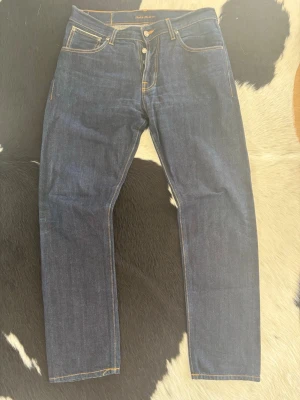 Nudie Jeans Steady Eddie Selvage - Tja, säljer nu dessa klassiska och snygga Steady Eddie I i selvage och inte II (nyare modellen).| Byxorna är i väldigt bra skick och har storleken W33 och L32.| Dubbelkolla gärna måtten på sista bilderna.| Bara att höra av er vid frågor eller funderingar.| 