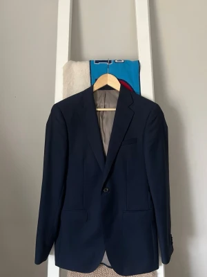 Mörkblå kavaj från Bläck - Stilren mörkblå kavaj från Bläck i modellen Tailored Fit. Den är väldigt fint skick. Nypris ligger på 1999kr.