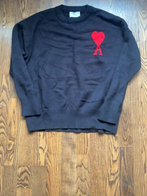 Svart stickad tröja från Ami Paris - Säljer en svart ami Paris tröja. Använda lite grann men i mycket bra skick. Storlek L men kan passa folk med M om dom vill att den sitter lite löst