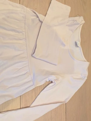 Ljusrosa långärmad body från Lindex - Supersöt ljusrosa body från Lindex med långa ärmar och rund halsringning. Tillverkad i mjukt och stretchigt material som sitter skönt på kroppen. Perfekt för dig som gillar en enkel och stilren look.