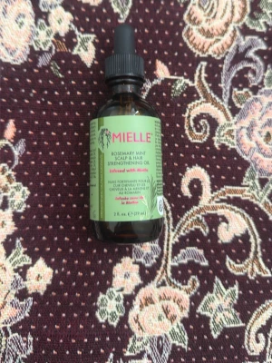 Mielle Rosemary Mint Strengthening Oil - Mielle Rosemary Mint Strengthening Oil är en närande hårolja för hårbotten och hår, berikad med rosmarin och mynta. Kommer i en brun glasflaska med pipett och grön etikett. Perfekt för dig som vill boosta håret med naturliga ingredienser. Bara testade!