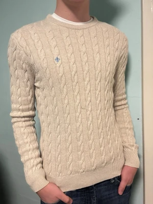 Morris beige kabelstickad tröja – M - Säljer en stilren beige kabelstickad tröja från Morris i storlek M. Perfekt för kyligare sommarkvällar och lätt att matcha. I mycket bra skick. Har du frågor? Tveka inte att höra av dig. Allt gott från Deluxe garderoben ⭐️