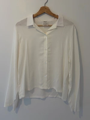 Vit skjorta  - Klassisk vit skjorta. Skjortan har lång ärm och är tillverkad i ett tunt, mjukt material som ger en stilren och clean look. 