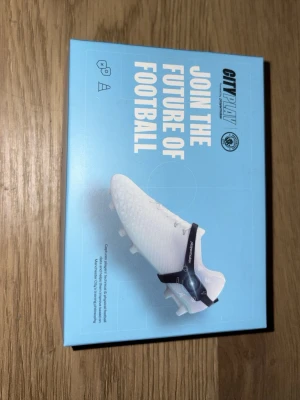 Pulsmätare CityPlay Playermaker - (Ordinarie pris=2000kr) Pulsmätare från CityPlay Playermaker, designad för fotbollsspelare. Kommer i en blå och vit förpackning. Produkten används för att mäta puls och prestation under träning och match. Enkel att fästa på skon och kopplas via Bluetooth.