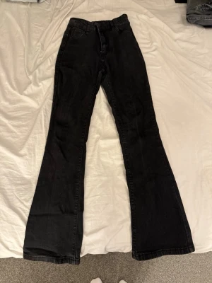 Svarta bootcut jeans - Säljer ett par svarta bootcut jeans med utsvängda ben från SHEIN. Jeansen har normal/hög midja.