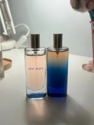 Giorgio Armani My Way parfym duo - Två flaskor av Giorgio Armani My Way parfym. En flaska har en ljusrosa vätska och den andra har en blå till orange gradient. Båda flaskorna är rektangulära med guldfärgade lock och genomskinligt glas.
