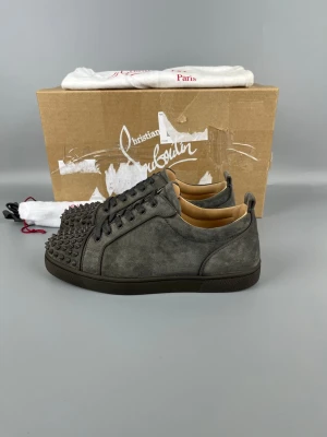 Mörkgrå Louboutin Skor Med Spikar - • The shoes have only been worn a few times and are in like-new condition  • Size: 40 (fits 40.5–41)  • Color: Dark Grey  • Retail price: 9500 SEK / 795€  • Box, dustbag & new laces included