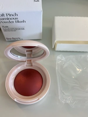Rare Beauty puder rouge - Puder rouge från Rare Beauty i färgen TRUTH. Kommer i en rund, ljusrosa dosa med spegel i locket och stilren logga på ovansidan. Perfekt för att ge kinderna en fräsch och naturlig glow. Fick den i gåva och aldrig blivit använd. Nypris 400kr