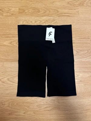 Svarta seamless tränings shorts - Svarta seamless shorts från DeFacto. De är tighta och stretchiga, perfekta för träning eller en sportig stil. Materialet är mjukt och följsamt mot kroppen