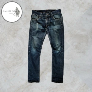 Nudie Jeans Taped Ted Dry Selvedge - Nudie Jeans Taped Ted Dry Selvedge jeans. Otroligt snygga jeans som har utvecklat en vacker patina, dessa typer av jeans är kända just för att utveckla snygga, personliga fades med tydlig karaktär.  Skick 7.5/10 inga märkvärdiga defekter, har mycket kvar att ge. Storlek W30/L30 men passar även W29. Hör av dig för mått!                                                                  ~ Liknande säljs för 1000–3000 kr | mitt pris 1 599 kr. Alla följare får rabatt, så följ!