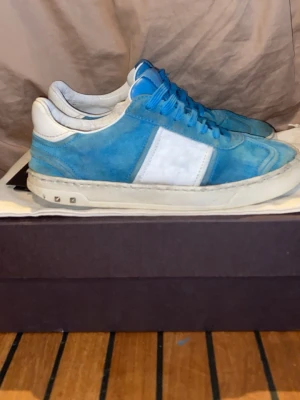 Blåa sneakers från Valentino - Valentino Flycrew sneakers – äkta – bra skick +   Säljer ett par stilrena Valentino Flycrew sneakers i blå/vit färg. Original och i bra skick, använda men fortfarande snygga.  Bekväma och lätta skor som passar både till vardag och lite mer uppklätt.  Detaljer:  * 12 av 22 originalnitar kvar * Sulan är ganska sliten (se bild)  Skick: Använda med tydligt slitage, därav priset Storlek: 39,5 Nypris: ca 7000–8000 kr Pris: 900 kr bara skorna med följer 
