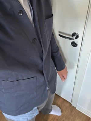 Blå overshirt från D'once de la sense  - Snygg blå overshirt  med klassisk krage och tre stora fickor framtill. Tillverkad i ett kraftigare bomullstyg som ger en stilren och avslappnad look. Perfekt att bära öppen över en skjorta eller t-shirt. FINNS I M OCH S, PRIS KAN FÖRHANDLAS