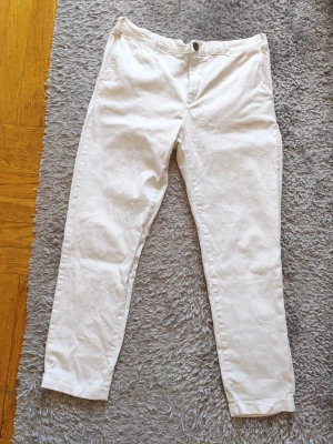 Vita Les Deux Chinos - Snygga vita chinos med rak passform och klassisk design. Byxorna har framfickor, bakfickor och bälteshällor. Perfekta för en clean och stilren look. Materialet känns mjukt och lätt, troligen bomull eller bomullsblandning.