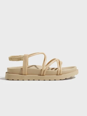 Beige sandaler med tunna remmar - Stilrena beige sandaler med flera tunna remmar och elastisk hälrem. Sandalerna har en chunky sula och är tillverkade i syntetmaterial med en matt finish. Perfekta för en avslappnad och trendig look under sommaren.