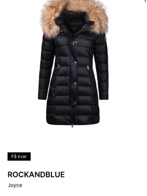 Svart  Rockandblue med pälshuva - Snygg svart lång från Rockandblue med avtagbar huva och stor beige fuskpälskant. Jackan har dragkedja, tryckknappar och två fickor med dragkedja framtill. Jackan har även 2 stora innerfickor, knappt använd är i jätte bra skick och kvalité. Perfekt för kalla vinterdagar och riktigt trendig look. Storlek 34/xs kan funka som s. Pris kan diskuteras