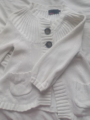 Gullig vit stickad kofta med stora knappar - Fin och gullig kortärmad kofta :) ❤️ Det är en XS men funkar utmärkt för dem som har M eller S i storlek 