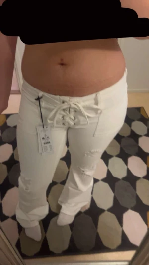 Vita bootcut low Rise Knut jeans  - Säljer mina vita low Rise bootcut pleated tie jeans från Gina tricot. De är i storlek L, passar M. De är knappt använda då de är lite stora på mig. Super snygga med snörena! Köpa för 400.