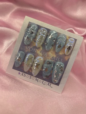 IcYOrBiT (XS);Medium Almond - Snygga handgjorda press-on naglar i en medium mandelform. Mix av glittrigt silverblått och nude med 3D-dekorationer, stjärnor och metalliska detaljer. Perfekt för dig som vill ha en unik och trendig look. Handgjorda och riktigt statement.XS: 14 mm, 11 mm, 11,5 mm, 10 mm, 8 mm 
