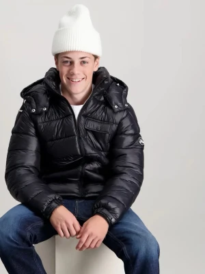 Svart pufferjacka från Maggiore - Säljer en svart pufferjacka från  Maggiore med avtagbar huva och dragkedja framtill. Jackan har flera fickor med lock och Maggiore-logga på ärmen. Perfekt för kalla vinterdagar, tillverkad i glansigt material som ger en cool look.