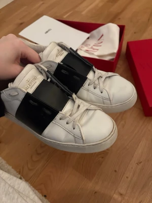Valentino vita sneakers med svart detalj - Säljer mina valentino skor i storlek 40. Orginalkartongen, dustbags och ett par extra skosnören medföljer. Har även äktesbevis jag skickar med. Tveka inte att höra av dig om du undrar något. 