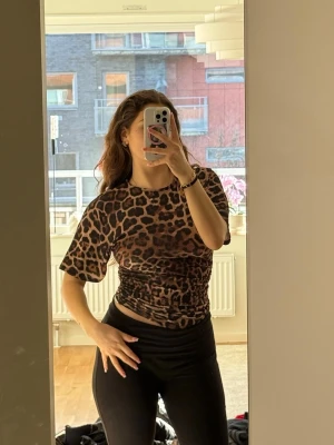Leopardmönstrad topp med snörning - Leopard mönstrad topp från NA-KD, super fin modell och rynkning i sidan för charmigare passform. Älskar denna topp men mönstret är helt enkelt inte för mig. Aldrig använt utöver bilderna! Originalpris: 299kr