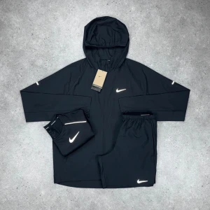 NIKE MILLER SET - 3 PIECE SVART - Nike Miller – 3-delar Svart • T-shirt, shorts & windbreaker i matchande färg • Storlekar från XS till 2XL • Går också att få på activez,se