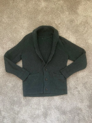 Tjock mörkgrön kofta - Snygg kofta i tjockare material, den är mörkgrön, dock syns inte det perfekt på bilden. Det finns inga defekter och koftan är i näst intill nyskick. Storlek: S. Skick: 9/10