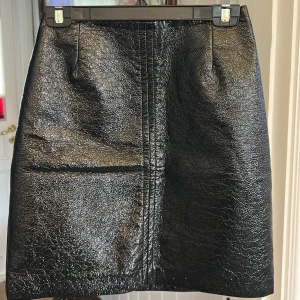 Svart skinnkjol med dragkedja - Snygg svart skinnkjol i kort modell med rak passform. 