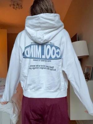 Berskha hoodie - Säljer en vit hoodie med stor blå text 'COOL MIND' på ryggen och mindre tryck framtill. Hoodien har luva, magficka och ribbade muddar. Oversized passform och casual stil, perfekt för chill dagar. Materialet känns mjukt och bekvämt.