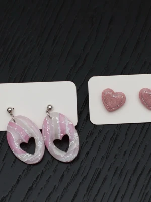 Handgjorda örhängen i polymerlera och stift i rostfritt stål rosa hjärta - Handgjorda örhängen i polymerlera och stift i rostfritt stål.  Självklart nya och oanvända. Storlek: Ovala med hjärtan 2x4cm. Små hjärtan (stiftörhängen) 1,5x1,5cm.  Färgerna kan variera beroende på skärminställningar.