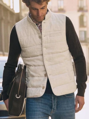 SAND VÄST NY - Stilren beige dunväst med raka paneler och knäppning framtill. Västen har en diskret bröstficka och står upp i kragen för en modern look. Perfekt att slänga över en hoodie eller tröja för extra värme. Passar till jeans och funkar året runt. Aldrig använd.