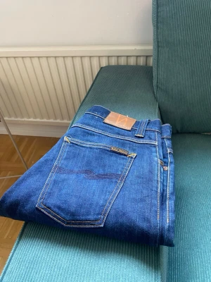 Nudie-jeans - Dark navy indigo denim Avrage Joe jean  - Säljer ett par sjysta par nudie jeans som är i bra skick. Gylf knappen är av så det är det  ända dåliga med det.  Modell: Avrage Joe  Storlek: W34 L32 Sid ben längd:105cm Inner ben: 76cm Waist :41cm  Ben öppning: 20cm  Lår vigd: 29-30 cm  Flera frågor så är det bara att fråga på !!  Pris kan diskuteras! 