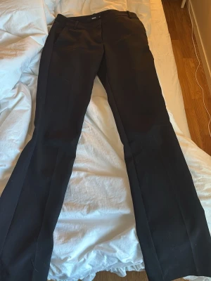 Svarta kostymbyxor med utsvängda ben - Snygga svarta kostymbyxor från bikbok