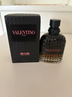 Valentino Uomo Born In Roma Coral Fantasy - Lyxig parfym från Valentino, Uomo Born In Roma Coral Fantasy. Flaskan är i glas med ett coolt nitat mönster och svart lock. Färgen går från svart upptill till bärnstensfärgad nedtill. Kommer med originalkartong i svart med rosa text. Flaskan är 100ml och oöppnad.