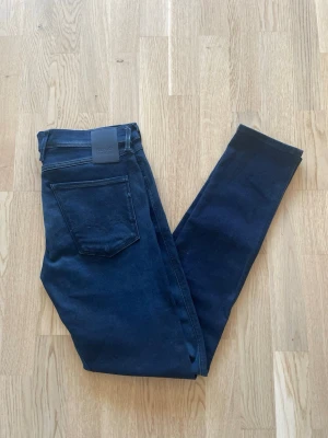 Svarta Replay Anbass jeans W33 L34  - Jag säljer dom här helt nya Replay Anbass jeansen i storlek W33 L34. De är bara provade och i utmärkt skick. Tveka inte att höra av er!        Mått: Längd=110cm. Midja=44cm