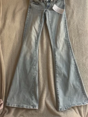 Ljusblå bootcut jeans Gina Tricot - Säljer ett par ljusblåa runaway jeans från Gina Tricot i storlek XS. Fick i present men passade inte i storleken. Bara testat det få antal gånger och aldrig använda då pris lappen står kvar. Perfekta för dig som gillar Stockholms stil  och vill ha ett par riktigt fina jeans med ett W på rumpa. OBS⚠️ kan sänka priset⚠️Dessa jeans är då också slut i butik och på nätet. Konakta mig om ni är intresserade puss💗💗