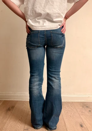 Lågmidjade bootcut jeans - Innerbenslängd: 80 cm                               Midjemått rakt över: 37 cm                       Grenlängd: 19 cm                                     Benöppning: 25 cm                                                  Har täcken på slitage vid benöppningen        Jeansen är sydda lågmidjat var därför försiktig med dem så att de inte spricker🩵