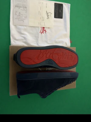 Mörkblå Louboutin skor - Jag säljer ett par mörkblå Louboutin skor i storlek 43, det finns en nackdel och det är att 8 piggar där framme är borta men går att beställa enkelt, man märker inte super mycket av de.